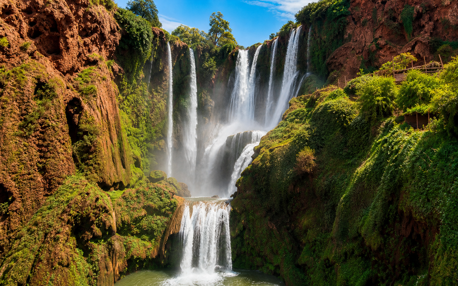 Ouzoud waterfalls with red cliffs and green gorge